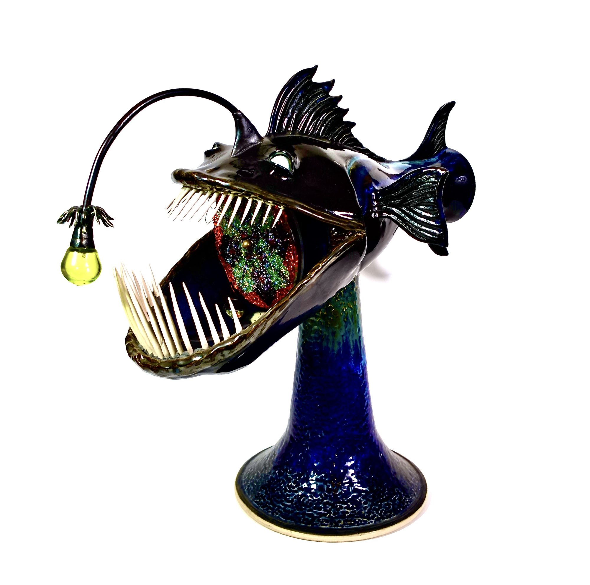Anglerfish sculpture with a glass lure bulb on a flared ceramic base