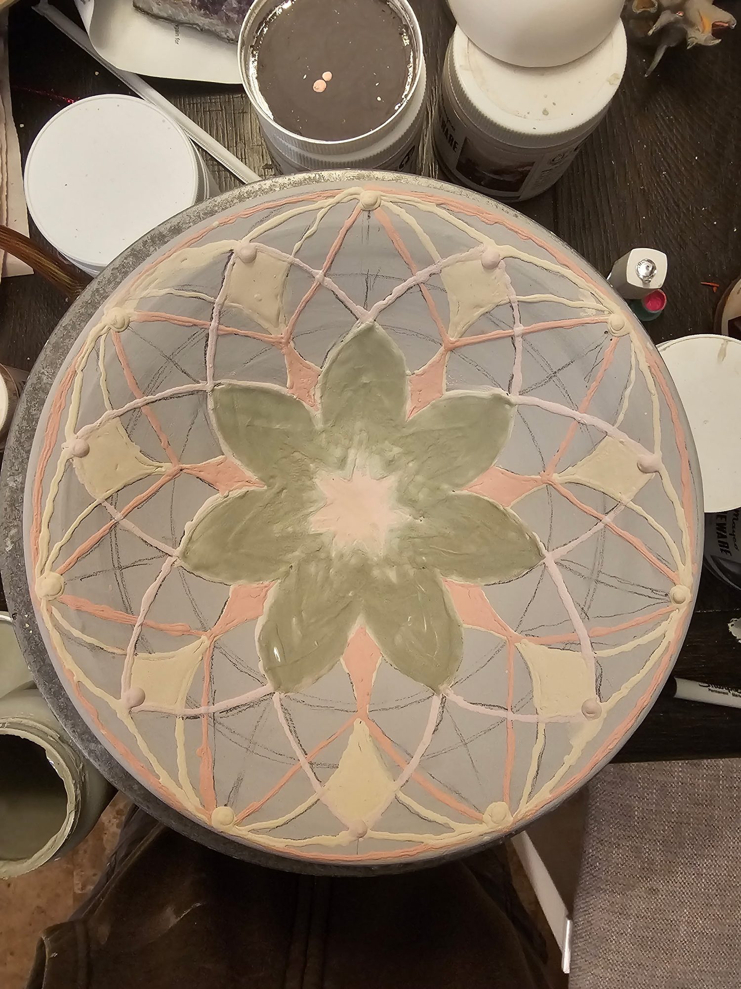Raw glaze laid into a mandala pattern on a platter